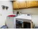 Bright laundry room with modern washer and dryer, upper cabinets, and convenient layout at 7533 Deerfield Dr, Greenfield, IN 46140