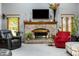 Cozy living room featuring a brick fireplace with a TV and mantle and plenty of seating at 7533 Deerfield Dr, Greenfield, IN 46140