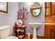 Charming powder room with pedestal sink, oval mirror, and decorative accents at 7533 Deerfield Dr, Greenfield, IN 46140