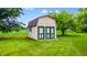 Outdoor storage shed with double doors in a well-maintained yard at 7533 Deerfield Dr, Greenfield, IN 46140