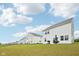 Backyard view of several white siding homes on a green lawn beneath a blue sky with clouds at 7834 Hillway Dr, Camby, IN 46113