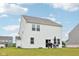 View of the house with a backyard featuring a grill, patio table, umbrella, and green grass at 7834 Hillway Dr, Camby, IN 46113