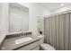 Clean bathroom with a modern sink, white cabinets, and a striped shower curtain next to a toilet at 7834 Hillway Dr, Camby, IN 46113