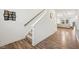 Hallway with wood-look flooring, stairs to the second floor, and a glimpse into the living room at 7834 Hillway Dr, Camby, IN 46113