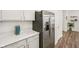 Modern kitchen features stainless steel refrigerator, white cabinets, quartz countertop, and wood-look flooring at 7834 Hillway Dr, Camby, IN 46113