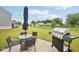 Outdoor patio featuring a glass table, chairs, grill, and umbrella in a spacious backyard at 7834 Hillway Dr, Camby, IN 46113