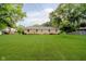 This home features a sprawling backyard, perfect for Gathering time, surrounded by lush greenery and shade at 8022 Hoover Ln, Indianapolis, IN 46260