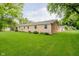 The home boasts a spacious, manicured backyard with healthy lawn and a charming brick exterior at 8022 Hoover Ln, Indianapolis, IN 46260