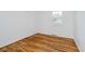 Bright bedroom with hardwood floors, white walls, and a window providing natural light and a view at 8022 Hoover Ln, Indianapolis, IN 46260