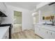 Well-lit kitchen with white cabinetry and stylish wood-look flooring at 8022 Hoover Ln, Indianapolis, IN 46260