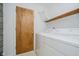 Functional laundry area with modern washer, dryer, shelving, and utility door at 8022 Hoover Ln, Indianapolis, IN 46260