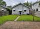 Backyard view of home with blue door, green lawn, brick patio and landscaped pathway at 810 N Bosart Ave, Indianapolis, IN 46201