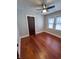 Bedroom featuring hardwood floors, ceiling fan, windows with blinds and dark trim door at 810 N Bosart Ave, Indianapolis, IN 46201