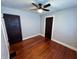 Bedroom features hardwood floors, ceiling fan, two dark doors and gray colored walls at 810 N Bosart Ave, Indianapolis, IN 46201