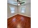 Bedroom featuring hardwood floors, neutral paint, modern ceiling fan, and natural light from two large windows at 810 N Bosart Ave, Indianapolis, IN 46201