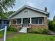 Charming home with a cozy front porch, brick accents, and a well-maintained lawn at 810 N Bosart Ave, Indianapolis, IN 46201