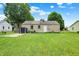 Spacious backyard featuring a well-maintained lawn, storage shed, and a quaint back entrance at 818 Vasbinder Dr, Chesterfield, IN 46017