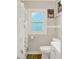 Bright bathroom featuring stylish shower curtain, wood-look floors and a textured glass window at 818 Vasbinder Dr, Chesterfield, IN 46017