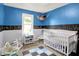 Charming Bedroom with blue accent wall, playful alphabet decorations and ample natural light at 818 Vasbinder Dr, Chesterfield, IN 46017