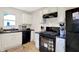 Well-lit kitchen with black appliances, white cabinets, and a functional layout at 818 Vasbinder Dr, Chesterfield, IN 46017