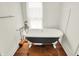 Elegant bathroom featuring a freestanding tub with claw feet, wood floors, and bright natural light at 838 Woodruff Place West Dr, Indianapolis, IN 46201