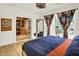 Bedroom featuring hardwood floors, a large closet, and a bright window with decorative curtains at 838 Woodruff Place West Dr, Indianapolis, IN 46201