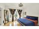 Bedroom featuring hardwood floors, a large mirror, and a bright window with decorative curtains at 838 Woodruff Place West Dr, Indianapolis, IN 46201