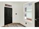 Entryway featuring hardwood floors, white walls, with a window and a black painted door at 838 Woodruff Place West Dr, Indianapolis, IN 46201