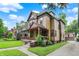 Stately home featuring a welcoming front porch with detailed trim, beautiful landscaping, and a long driveway at 838 Woodruff Place West Dr, Indianapolis, IN 46201