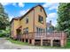 Charming two-story home with a raised deck and wood storage underneath, set against a backdrop of lush greenery at 838 Woodruff Place West Dr, Indianapolis, IN 46201