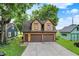 Two-car garage with upper-level living space, surrounded by mature trees and blue skies, offering ample parking at 838 Woodruff Place West Dr, Indianapolis, IN 46201
