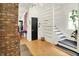 Hallway featuring hardwood floors, brick accents, and a modern staircase at 838 Woodruff Place West Dr, Indianapolis, IN 46201