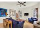 A well-lit living room with hardwood floors and white walls featuring a blue sofa and eclectic art at 838 Woodruff Place West Dr, Indianapolis, IN 46201