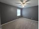 Bedroom with gray walls, neutral carpet, ceiling fan, and a window for natural light at 8433 Fairwind Ct, Indianapolis, IN 46256
