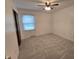 Bright bedroom with neutral carpet, ceiling fan, and window with blinds at 8433 Fairwind Ct, Indianapolis, IN 46256