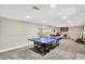 Large recreation room with a ping pong table, wet bar, and seating areas at 8924 Stormhaven Ct, Indianapolis, IN 46256