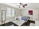Well-lit bedroom features hardwood floors, a ceiling fan and a large window with blinds at 8924 Stormhaven Ct, Indianapolis, IN 46256