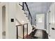 Bright foyer featuring a modern staircase with metal railings and sleek, dark hardwood floors at 8924 Stormhaven Ct, Indianapolis, IN 46256