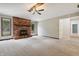 Spacious living room featuring a brick fireplace, neutral carpet, and natural light from large windows at 9189 Dawn Dr, Brownsburg, IN 46112