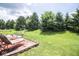 Relax on the brick patio of this home's expansive backyard, surrounded by lush greenery and mature trees at 9215 Stones Bluff Pl, Indianapolis, IN 46113