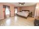 A spacious bedroom with light wood floors, ceiling fan, and large window at 9215 Stones Bluff Pl, Indianapolis, IN 46113