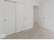 Neutral carpeted bedroom with a closet and open door with views into another room at 10107 Camp Creek Way, Indianapolis, IN 46229