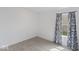 Simple bedroom with neutral carpet, white walls and a large window with colorful patterned curtains at 10107 Camp Creek Way, Indianapolis, IN 46229