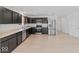 Spacious kitchen with dark cabinets, stainless steel appliances, and wood-look flooring, with access to the entryway at 10107 Camp Creek Way, Indianapolis, IN 46229