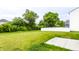Spacious backyard is surrounded by trees and a privacy fence, with a concrete pad at 10210 Samerton Ln, Indianapolis, IN 46239