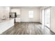 A bright kitchen and living area feature stainless steel appliances and hardwood style flooring at 10210 Samerton Ln, Indianapolis, IN 46239