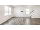 Spacious living room with wood-look floors, bright white walls, and large windows at 10210 Samerton Ln, Indianapolis, IN 46239