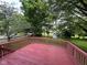 View of a back deck overlooking a grassy backyard with mature trees and a wooden privacy fence at 10316 Woodhaven Cir, Indianapolis, IN 46229