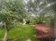 Lush backyard view from a window, featuring a deck, mature trees, and green grass at 10316 Woodhaven Cir, Indianapolis, IN 46229