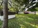 Large, grassy backyard features a shed, mature trees, and a wood deck, offering ample space at 10316 Woodhaven Cir, Indianapolis, IN 46229